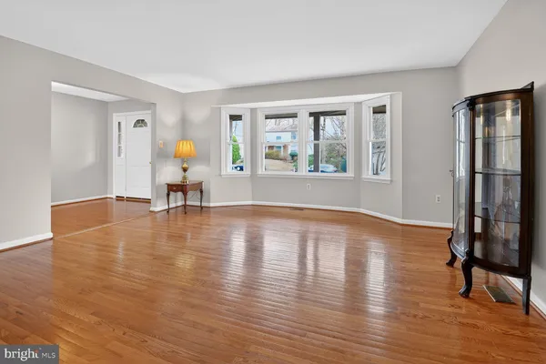 a view of empty room with kitchen and windows