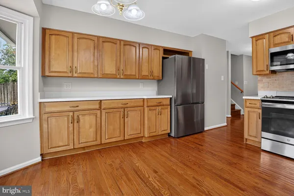 a kitchen with wooden floors and appliances