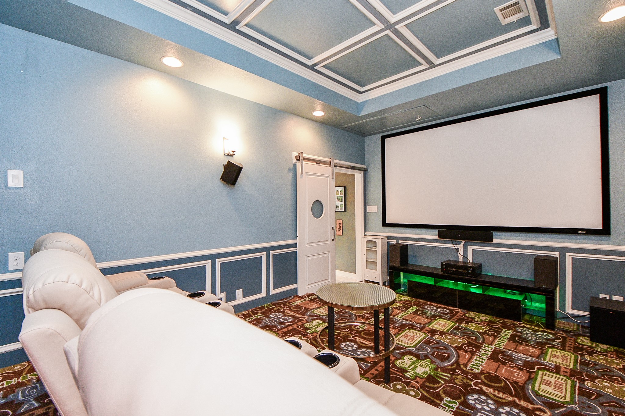 263 Wood Loop Street Houston, TX 77015 - Photo 9 of 45 This photo showcases a stylish home theater room featuring comfortable reclining seats, a large projector screen, and ambient lighting. The room is designed with blue walls and decorative ceiling panels, offering a cozy entertainment space.