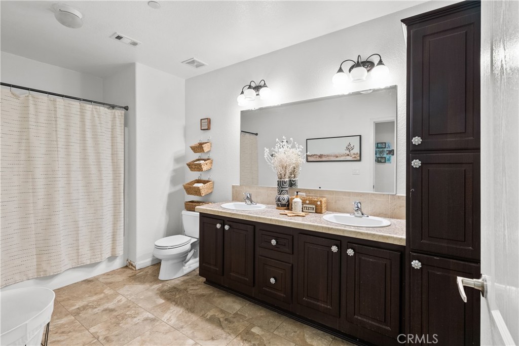 31053 Hasley Canyon Road Castaic, CA 91384 - Photo 20 of 50 a spacious bathroom with a double vanity sink toilet and a mirror