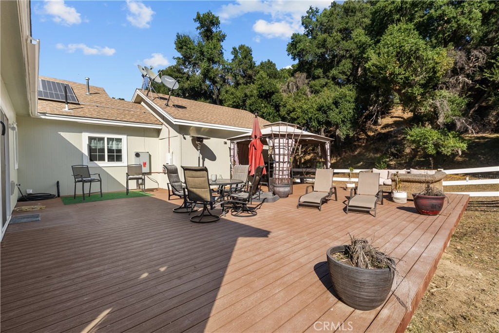 31053 Hasley Canyon Road Castaic, CA 91384 - Photo 35 of 50 a view of a patio with table and chairs potted plants with wooden floor and fence