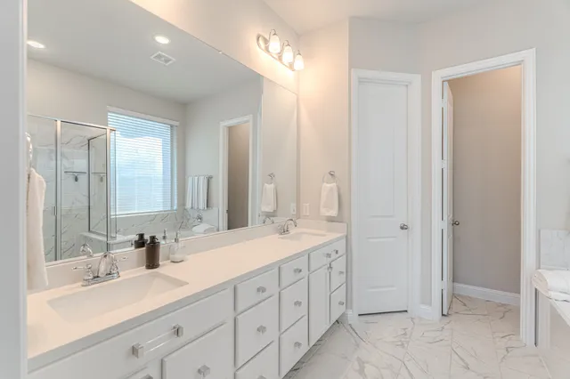 a bathroom with double sink and a mirror