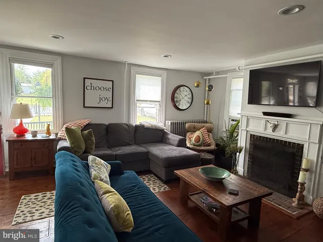 a living room with furniture a flat screen tv and a fireplace
