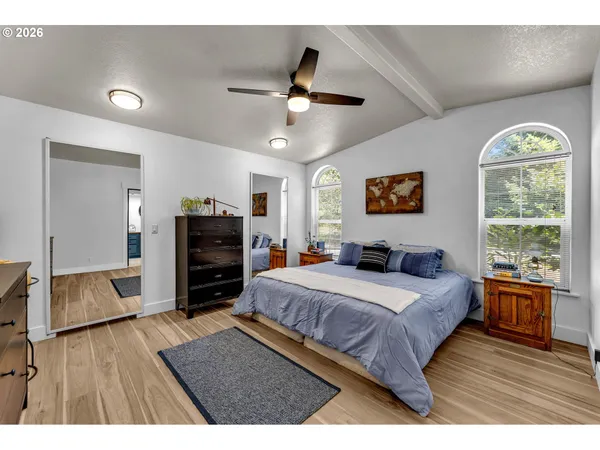 a bedroom with a bed and wooden floor