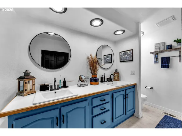 a bathroom with a toilet sink double vanity and mirror