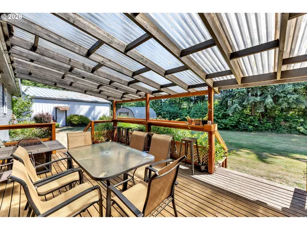 a view of a patio with table and chairs with wooden floor and fence