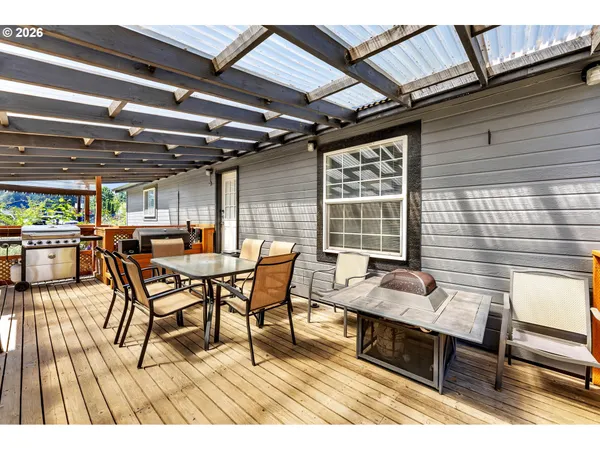 a roof deck with a dining table and chairs with wooden floor
