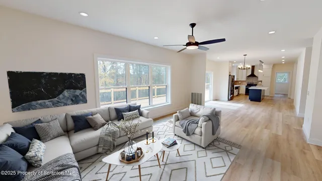 a view of a livingroom with a ceiling fan & a ceiling fan