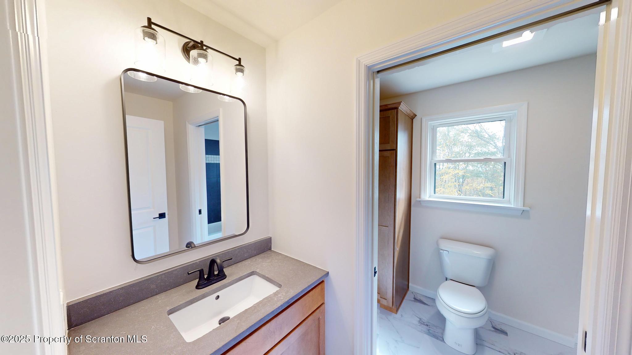 99 Woodland Drive Lake Ariel, PA 18436 - Photo 94 of 124 a bathroom with a toilet sink and mirror