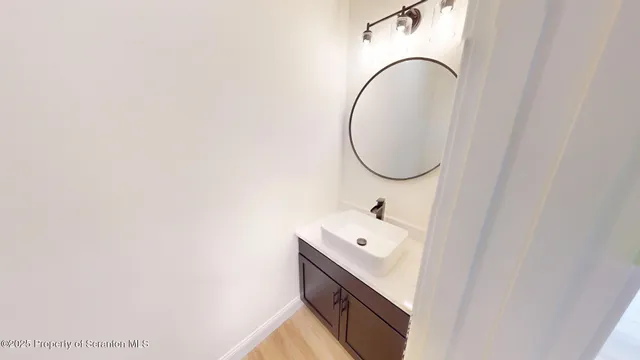 an empty room with chandelier fan and windows