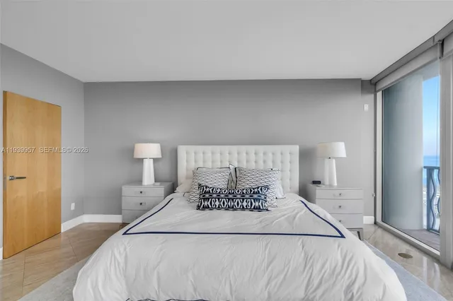 a bed sitting in a bedroom next to a lamp