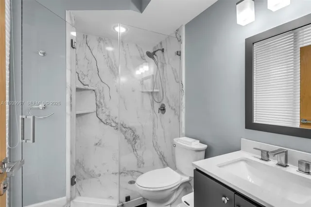 a bathroom with a sink toilet a mirror and shower