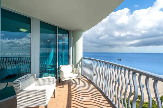 a view of a patio with couches chairs and a floor to ceiling window