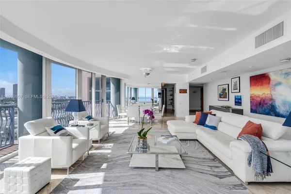 a living room with furniture and large windows