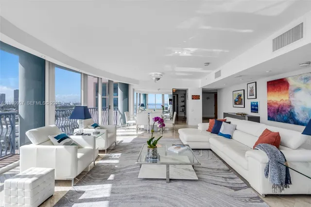 a living room with furniture and large windows