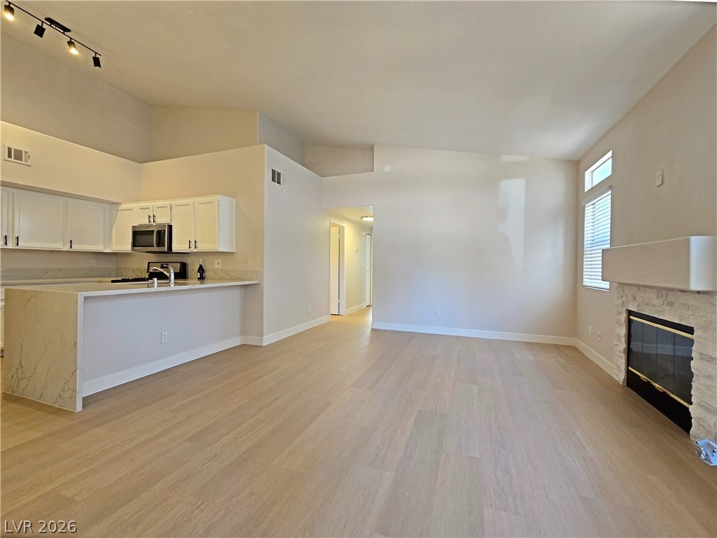 5370 Runningbrook Road Las Vegas, NV 89120 - Photo 29 of 30 An open floor plan seamlessly connects the kitchen and living area, highlighted by a modern fireplace.