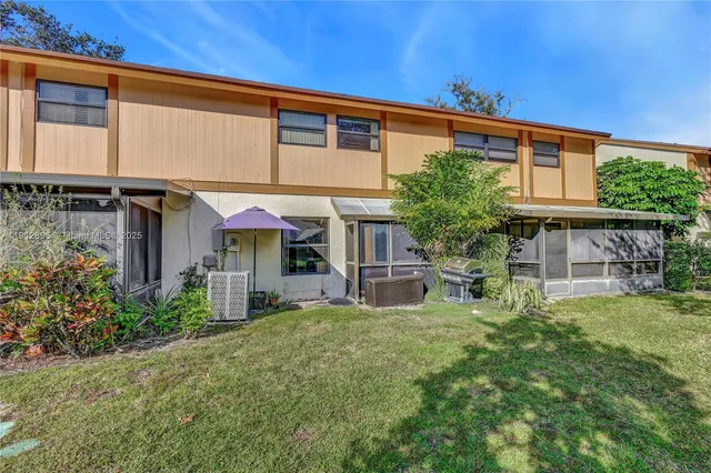 a view of a house with patio and a yard