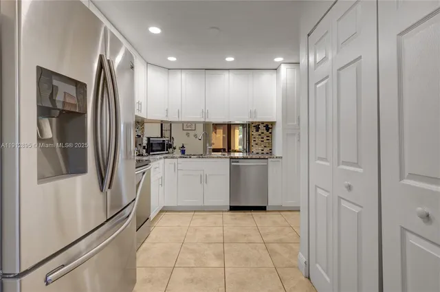 a kitchen with a refrigerator sink and cabinets