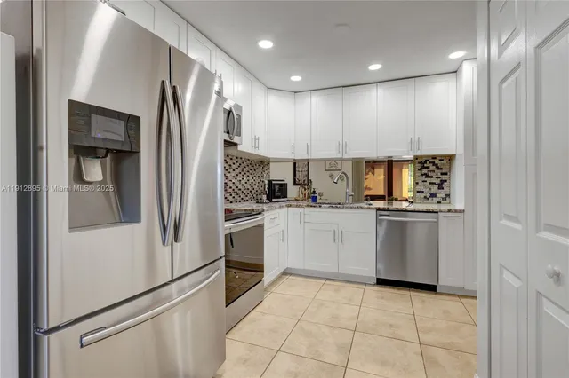 a kitchen with white cabinets and white appliances