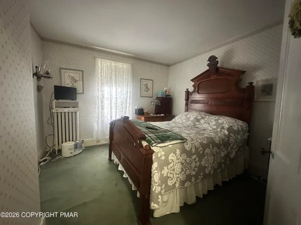 a bed sitting in a bedroom next to a window and a livingroom