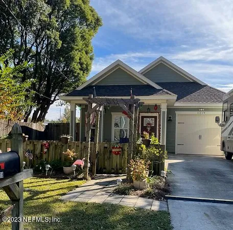 a view of a house with a backyard and a tree