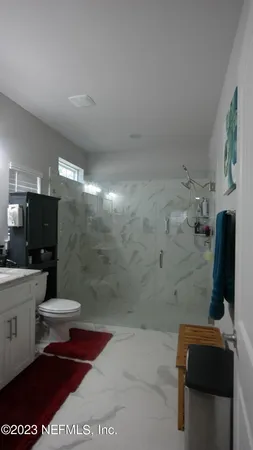 a bathroom with a granite countertop sink toilet and shower