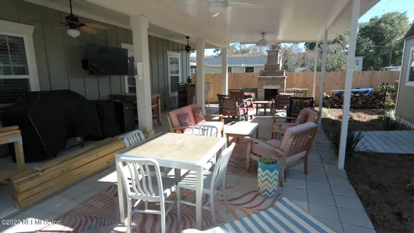 a view of a dining room with furniture a kitchen and chandelier