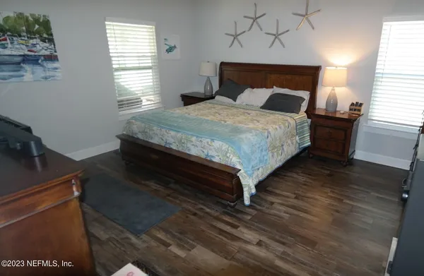 a bed sitting in a bedroom next to a window with a dresser
