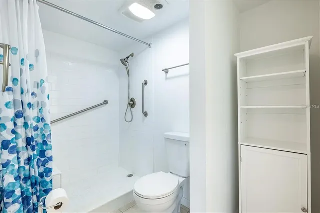 a white toilet sitting next to a shower curtain