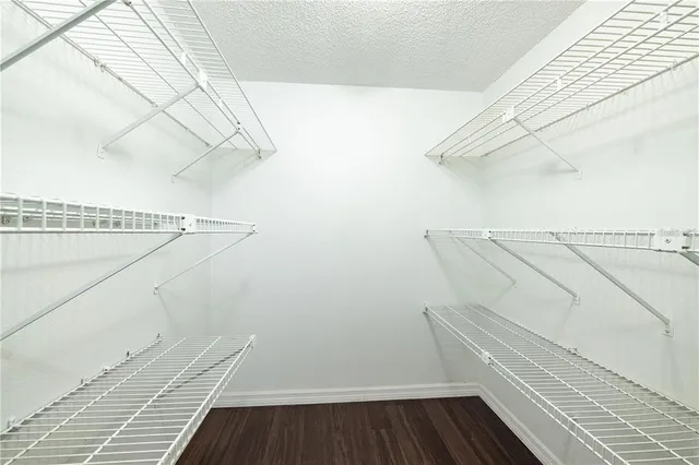 a view of walk in closet with wooden floor