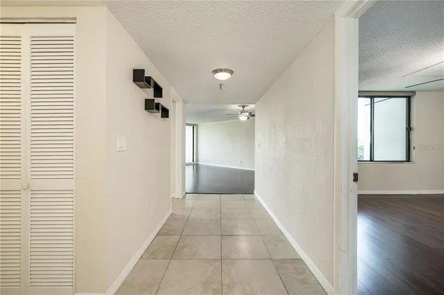 a view of a hallway with wooden floor and a bathroom