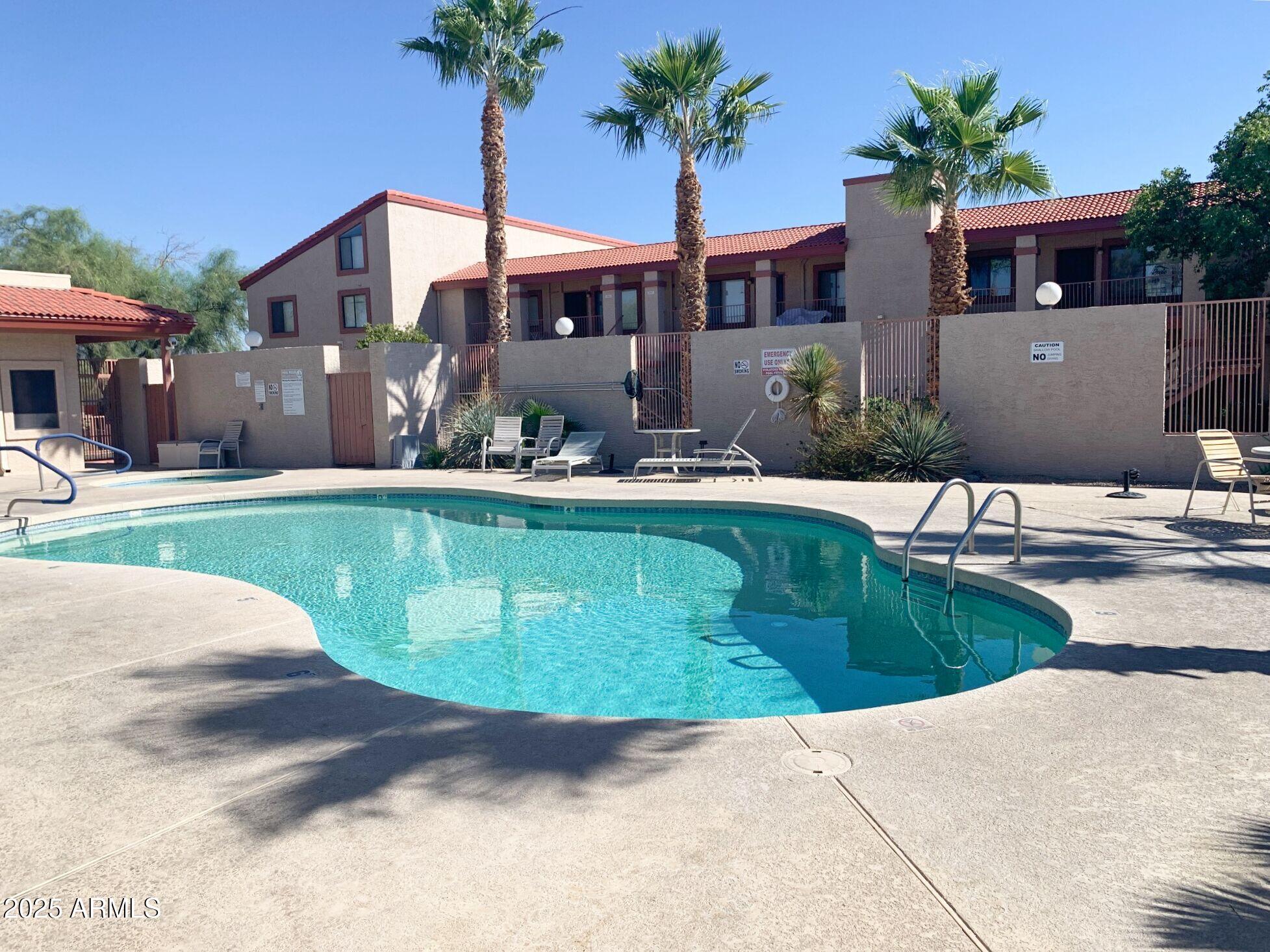 1440 North Idaho Road, Unit 1019 Apache Junction, AZ 85119 - Photo 1 of 14 a view of a house with a yard and potted plants