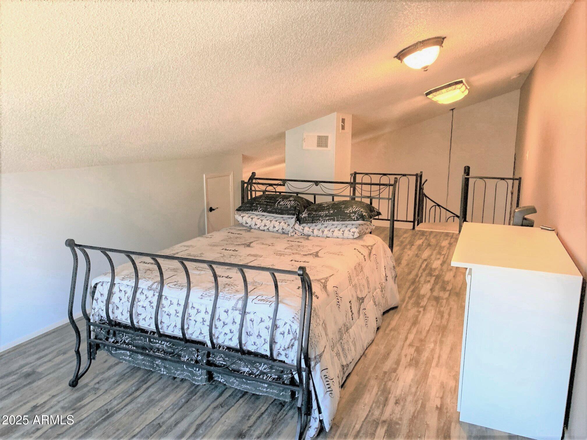 1440 North Idaho Road, Unit 1019 Apache Junction, AZ 85119 - Photo 10 of 14 a bed sitting in a bedroom next to a lamp