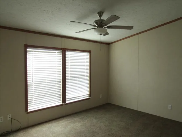 an empty room with a window and a fan