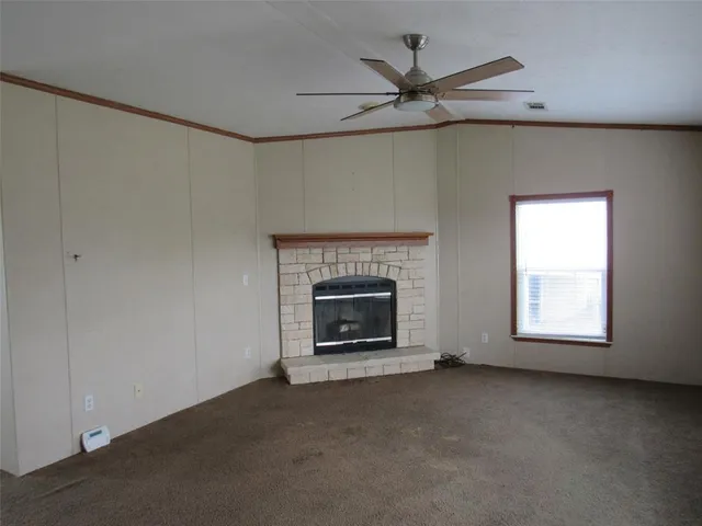 an empty room with fireplace and windows