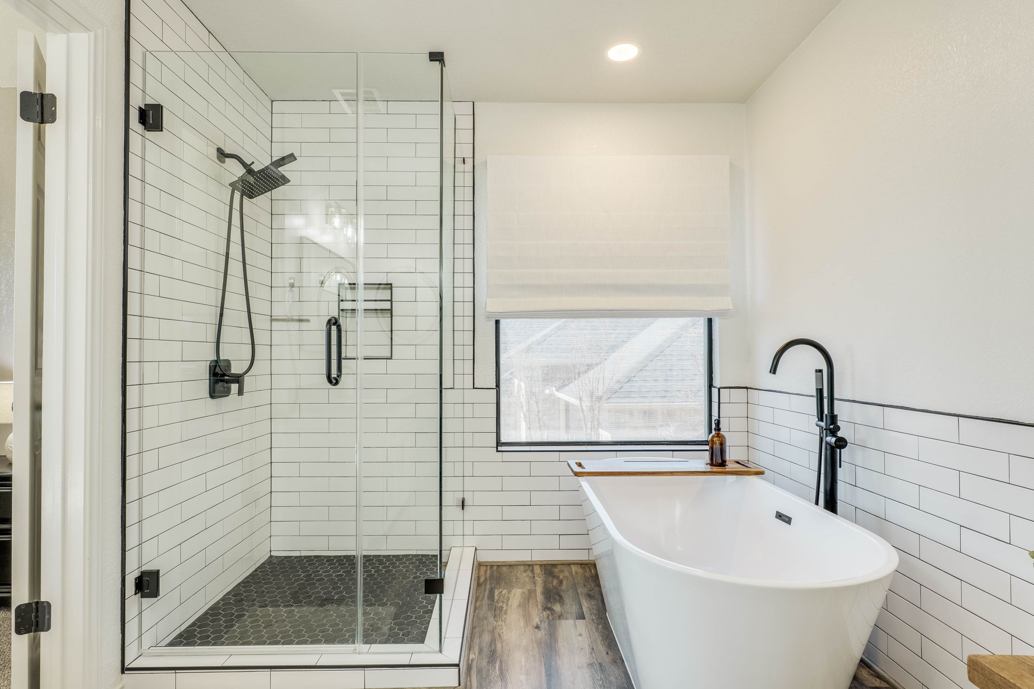 703 Ridge View Drive Leander, TX 78641 - Photo 24 of 39 Bathroom featuring tile walls, a stall shower, a soaking tub, wainscoting, and recessed lighting