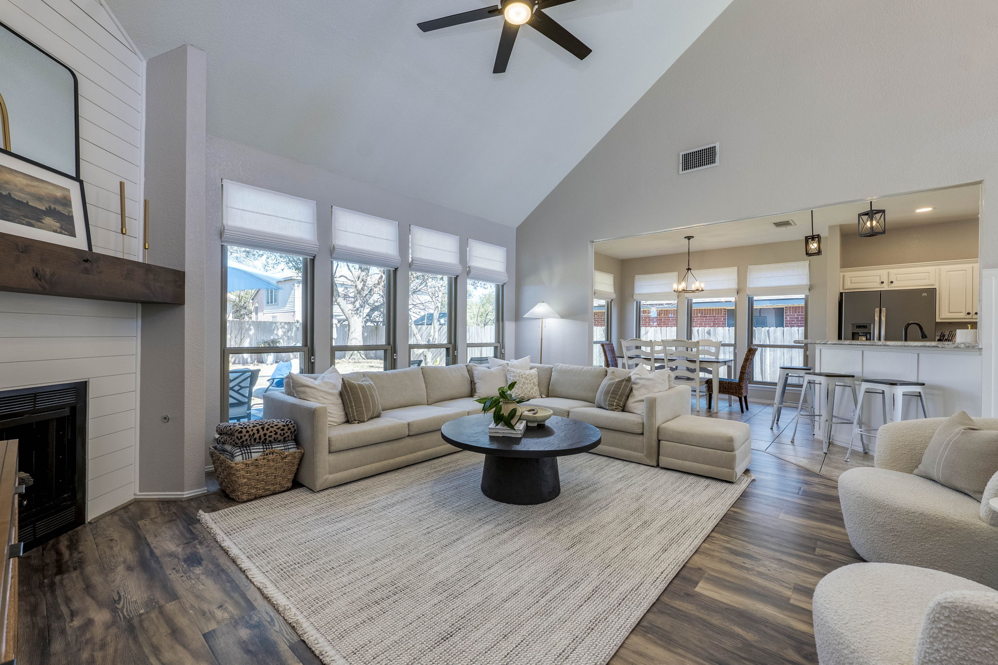 703 Ridge View Drive Leander, TX 78641 - Photo 10 of 39 Living area featuring dark wood-style flooring, lofted ceiling, a ceiling fan, a large fireplace, and hanging lights