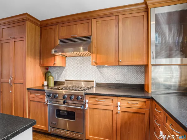 a kitchen with stainless steel appliances wooden cabinets and a stove top oven