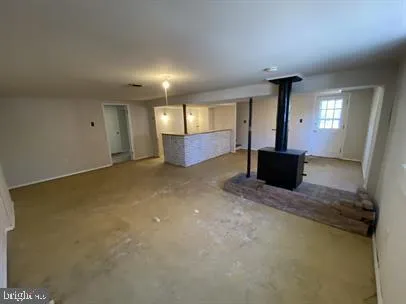 an empty room with windows and fireplace
