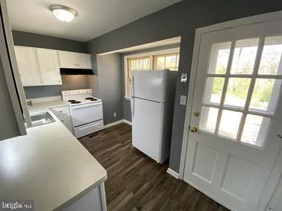 a kitchen with a refrigerator a stove top oven and a large window