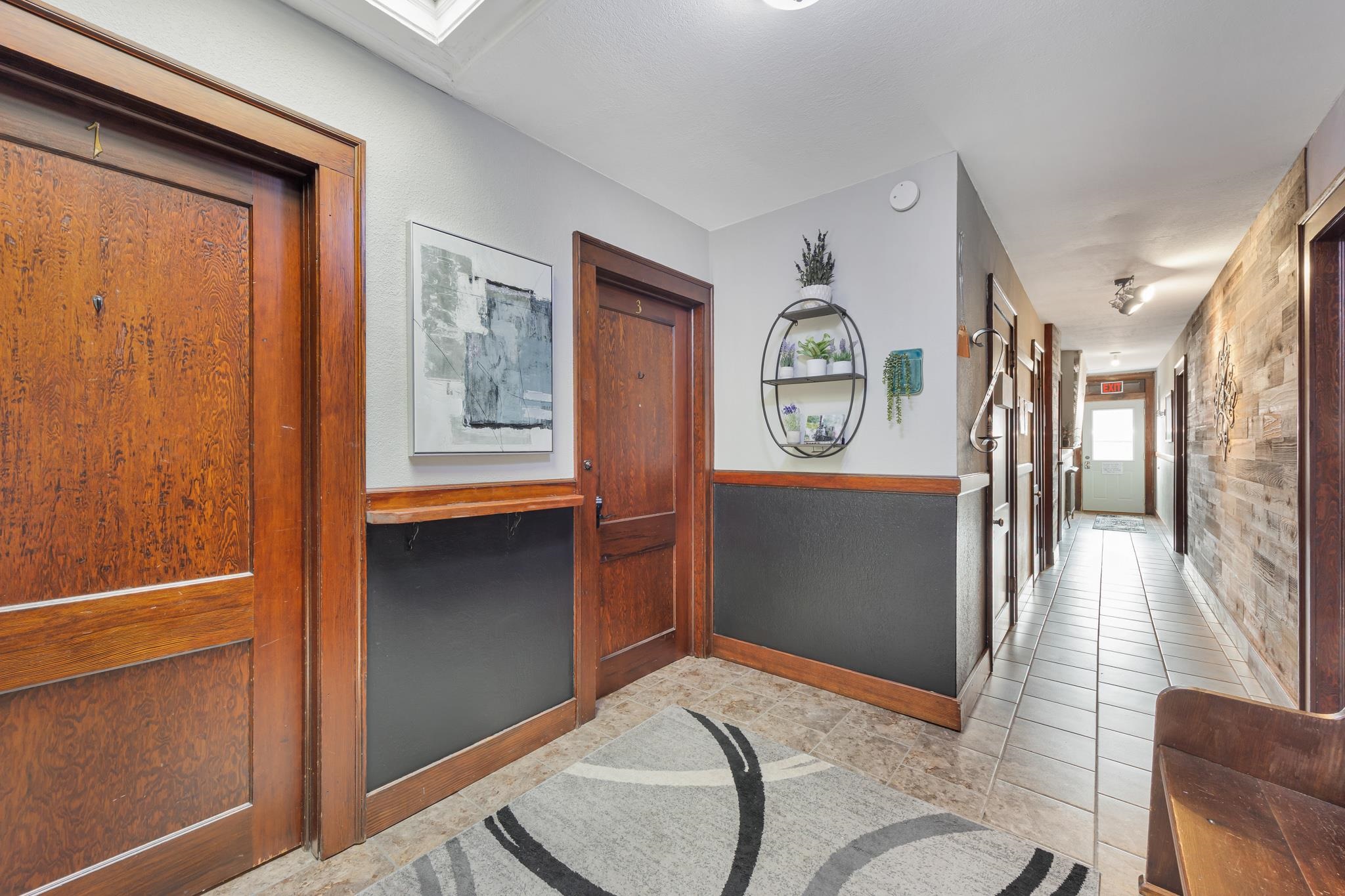 601 1st Avenue Two Harbors, MN 55616 - Photo 23 of 99 Hallway allowing access to the STR apartments, entrance staircase, laundry room, backdoor and back deck - featuring original Douglas fir woodwork