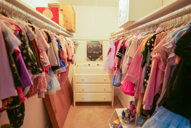 a view of walk in closet with clothes