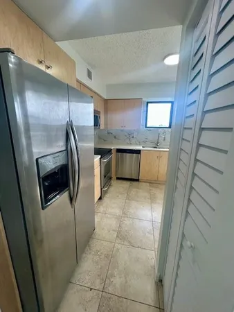a large kitchen with a stove a sink and a refrigerator
