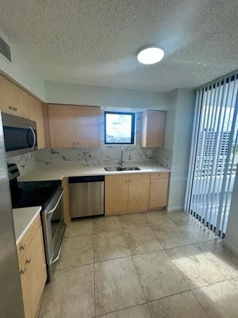 a kitchen with a sink and steel appliances