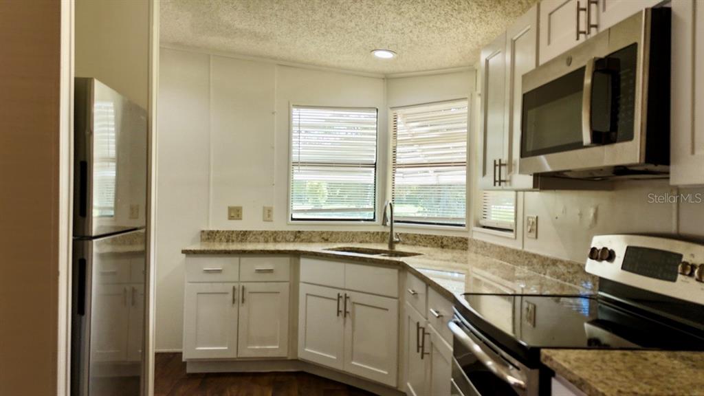 a kitchen with a sink stove and microwave