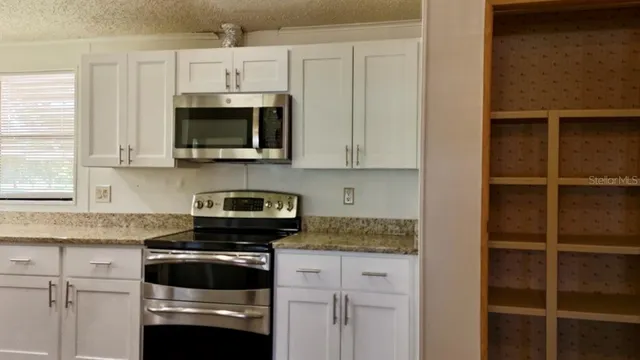 a kitchen with appliances cabinets and a window