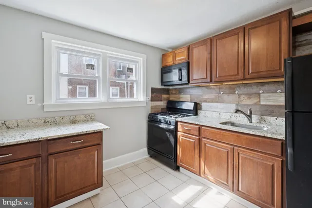 a kitchen with stainless steel appliances granite countertop a sink stove and cabinets
