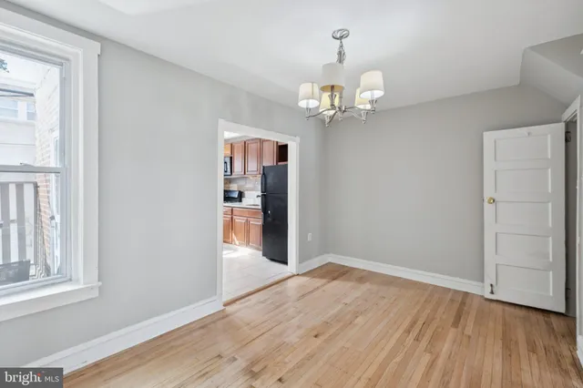 a view of empty room with wooden floor and window