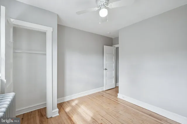 an empty room with wooden floor and closet area