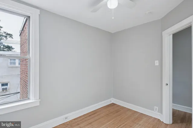 a view of a small space with wooden floor and a window